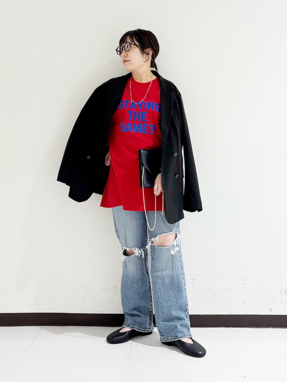 ブラック系のバレエシューズ、ブラック系のその他アウター、レッド系のTシャツ/カットソーを着用したレディースの秋コーディネートの5枚目の写真