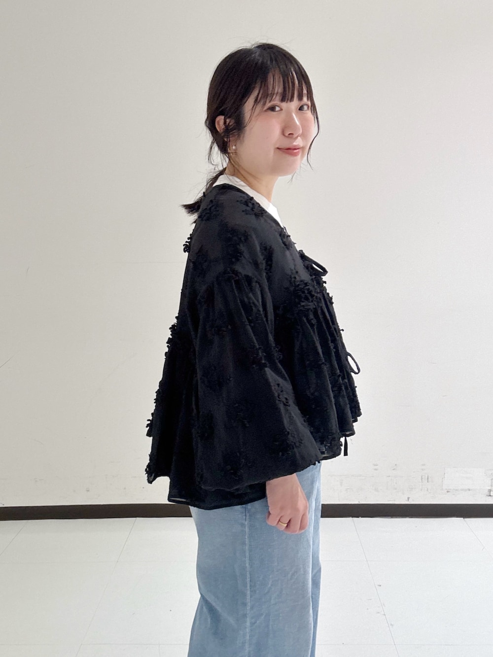 レッド系のTシャツ/カットソー、ブルー系のデニムパンツ、ブラック系のシャツ/ブラウスを着用したレディースの春コーディネートの3枚目の写真