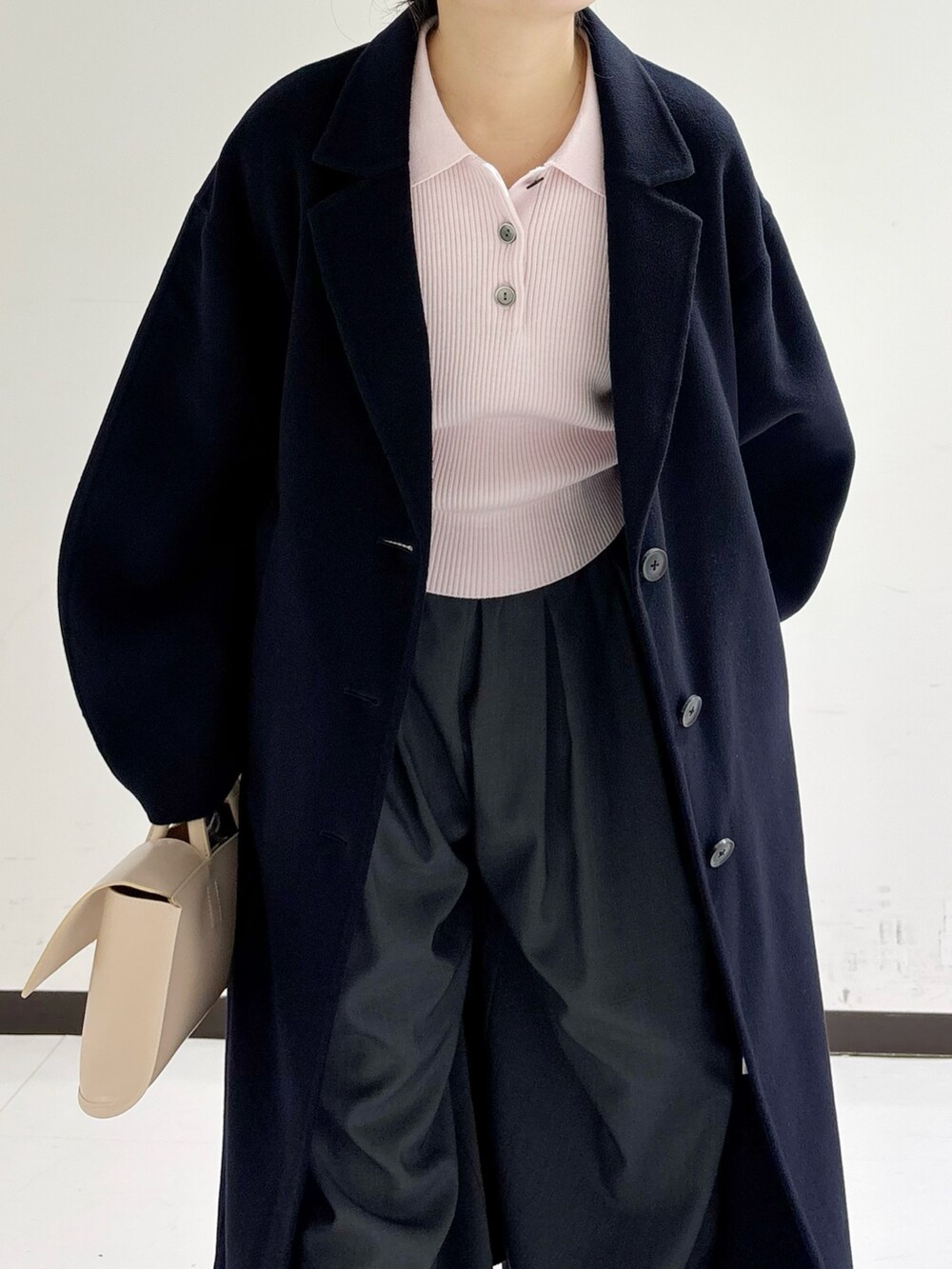 イエロー系のハンドバッグ、ピンク系のニット/セーター、ブルー系のテーラードジャケットを着用したレディースの冬コーディネートの7枚目の写真