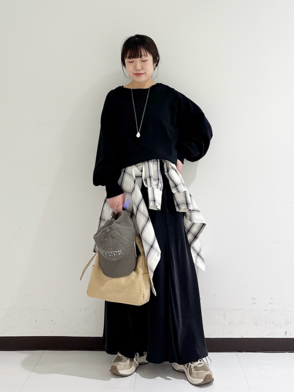 ブラック系のスウェット、ホワイト系のシャツ/ブラウス、ベージュ系のショルダーバッグを着用したレディースの冬コーディネートの5枚目の写真