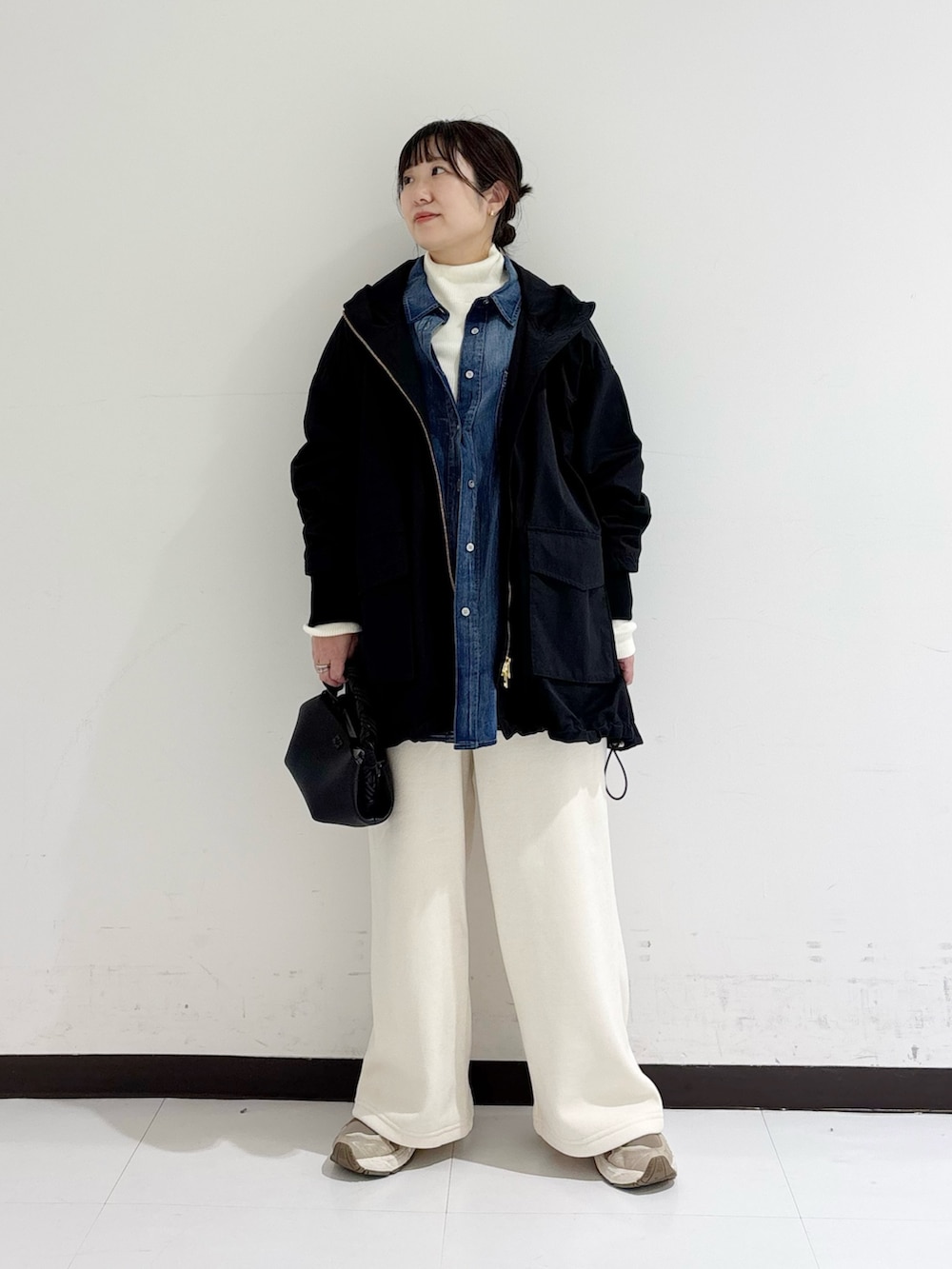 ホワイト系のニット/セーター、ブルー系のシャツ/ブラウス、ブラック系のマウンテンパーカーを着用したレディースの秋コーディネートの5枚目の写真