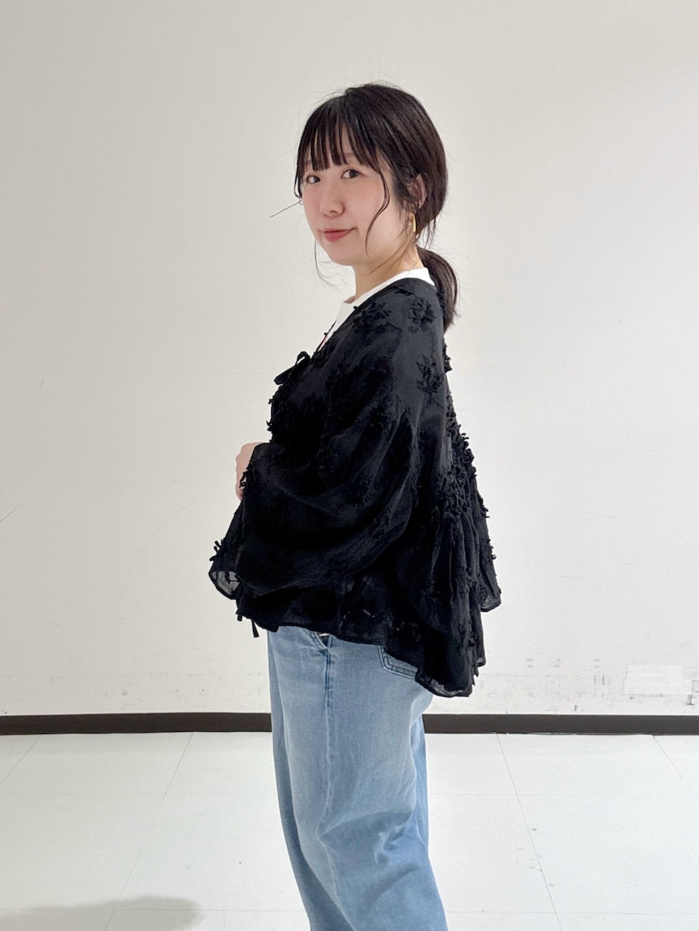 レッド系のTシャツ/カットソー、ブルー系のデニムパンツ、ブラック系のシャツ/ブラウスを着用したレディースの春コーディネートの2枚目の写真