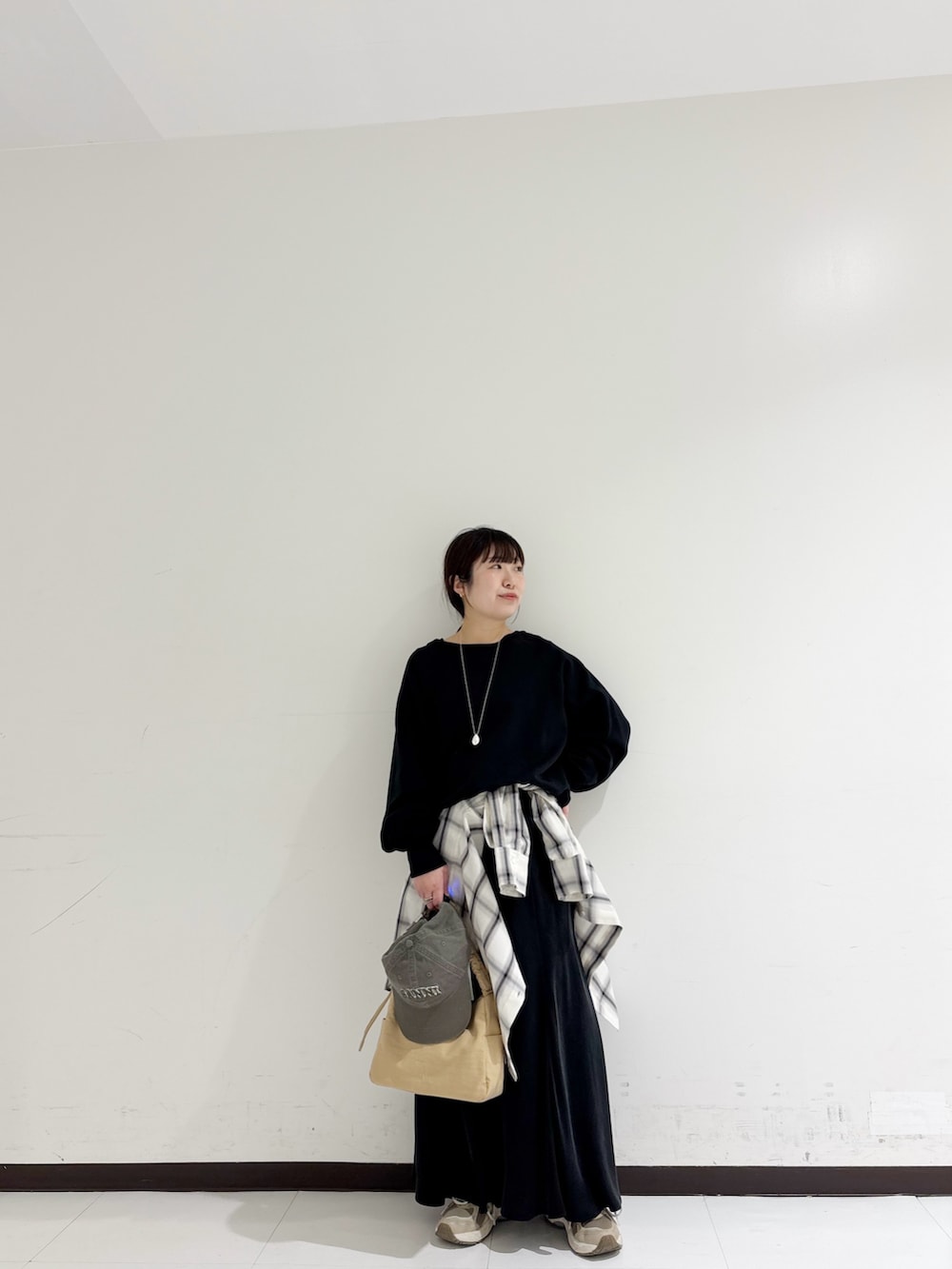 ブラック系のスウェット、ホワイト系のシャツ/ブラウス、ベージュ系のショルダーバッグを着用したレディースの冬コーディネートの6枚目の写真