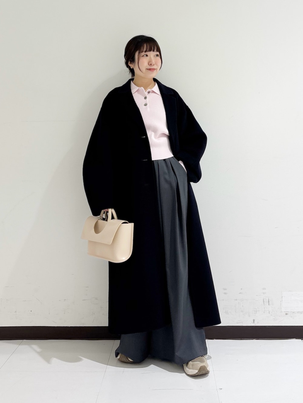 イエロー系のハンドバッグ、ピンク系のニット/セーター、ブルー系のテーラードジャケットを着用したレディースの冬コーディネートの5枚目の写真