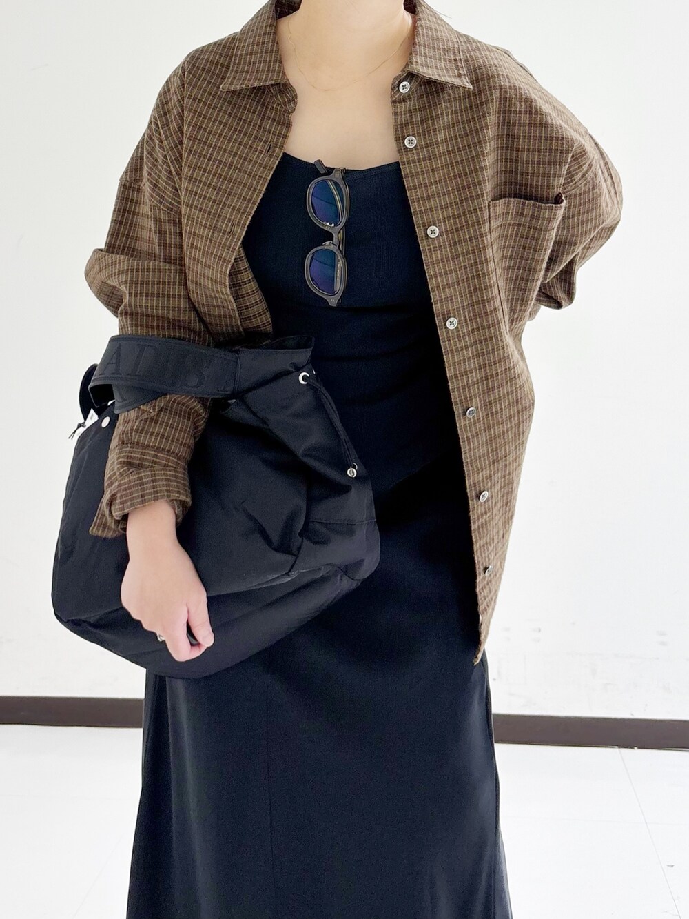 ブラウン系のシャツ/ブラウス、ブラック系のタンクトップ、ブラック系のショルダーバッグを着用したレディースの秋コーディネートの7枚目の写真