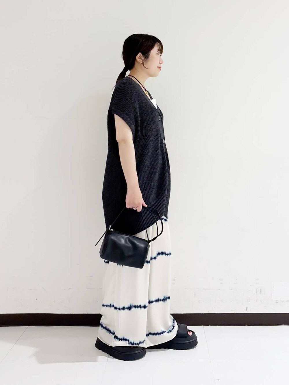 ホワイト系のタンクトップ、ホワイト系のその他パンツ、ブラック系のショルダーバッグを着用したレディースの夏コーディネートの4枚目の写真