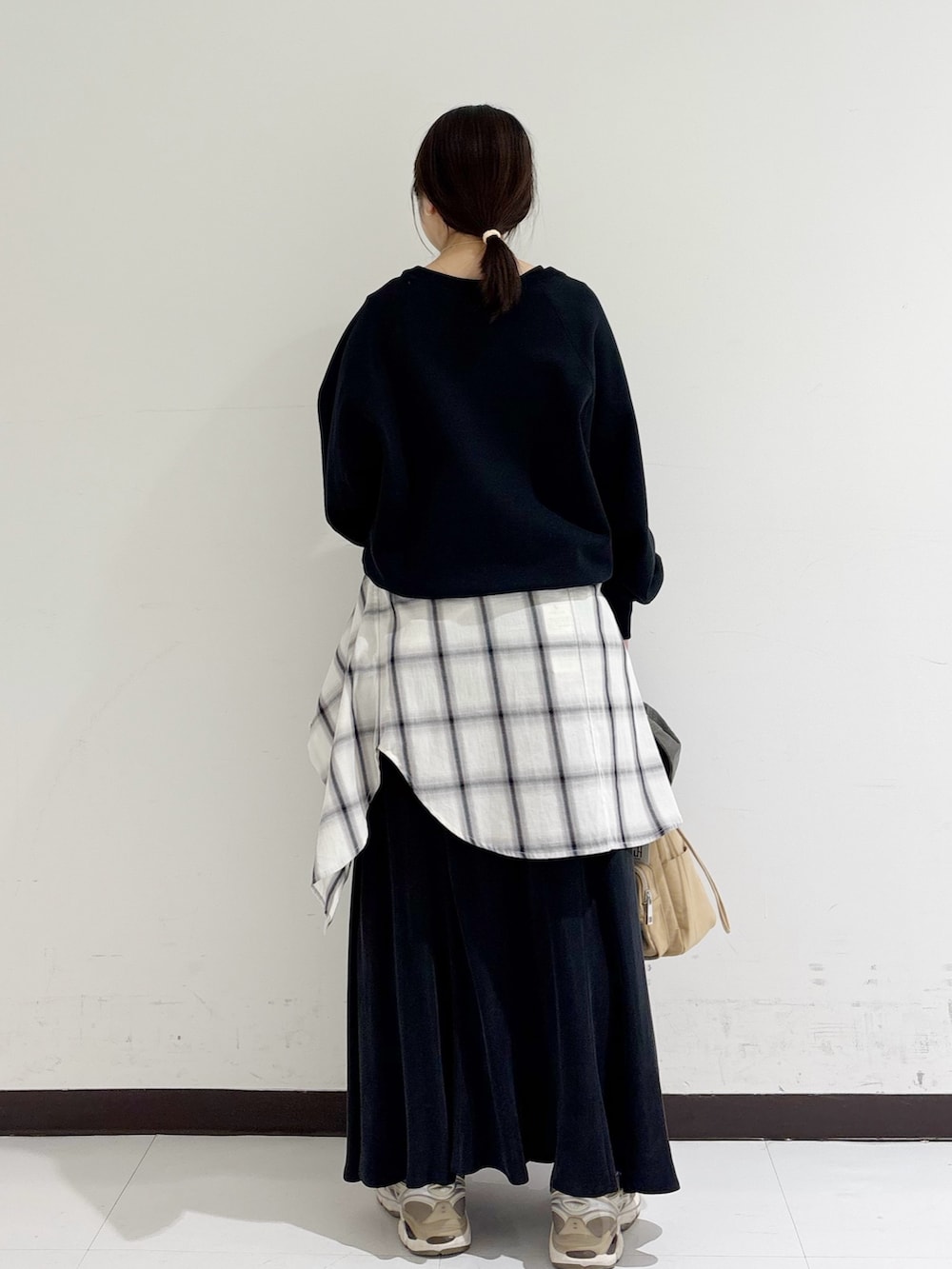 ブラック系のスウェット、ホワイト系のシャツ/ブラウス、ベージュ系のショルダーバッグを着用したレディースの冬コーディネートの3枚目の写真