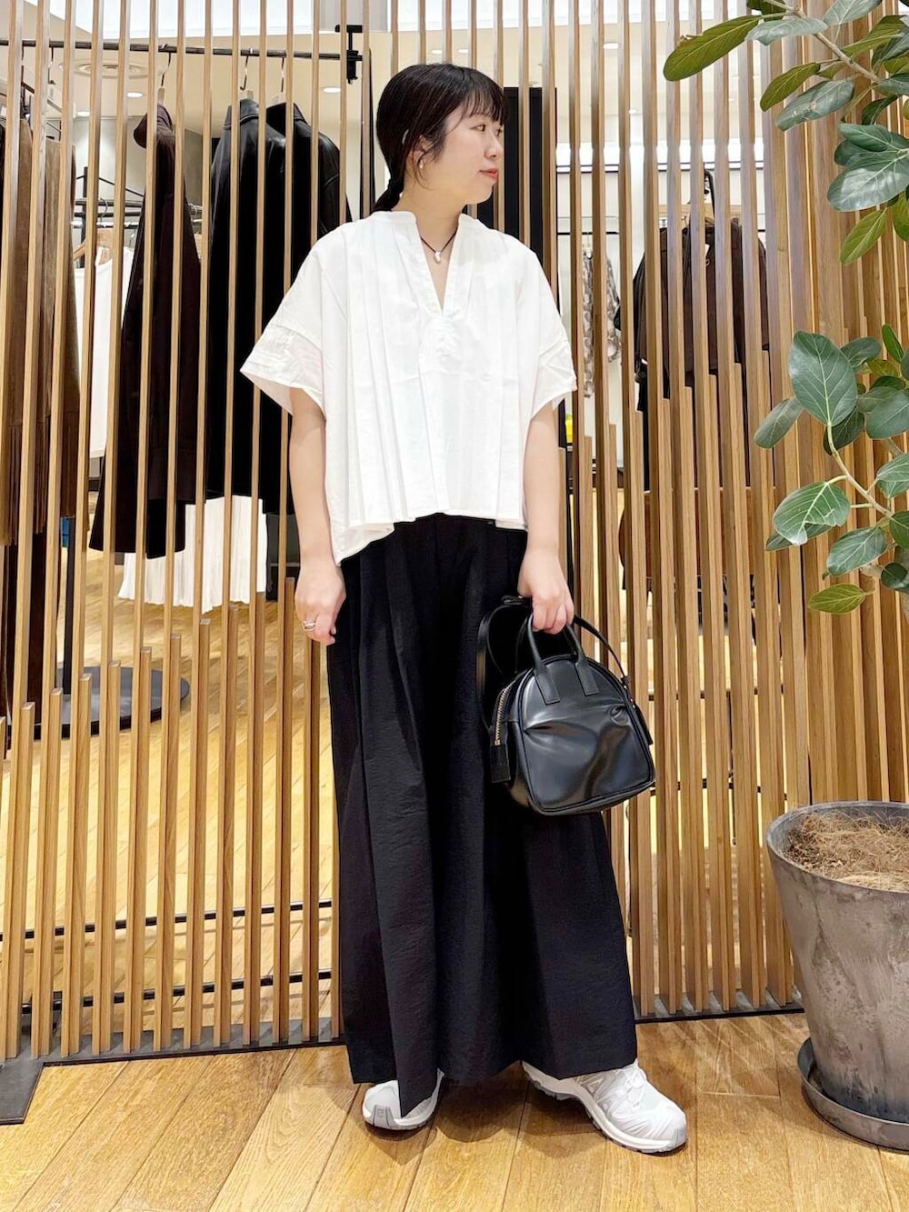 ブラック系のショルダーバッグ、ブラック系のその他パンツ、ホワイト系のシャツ/ブラウスを着用したレディースの夏コーディネートの4枚目の写真