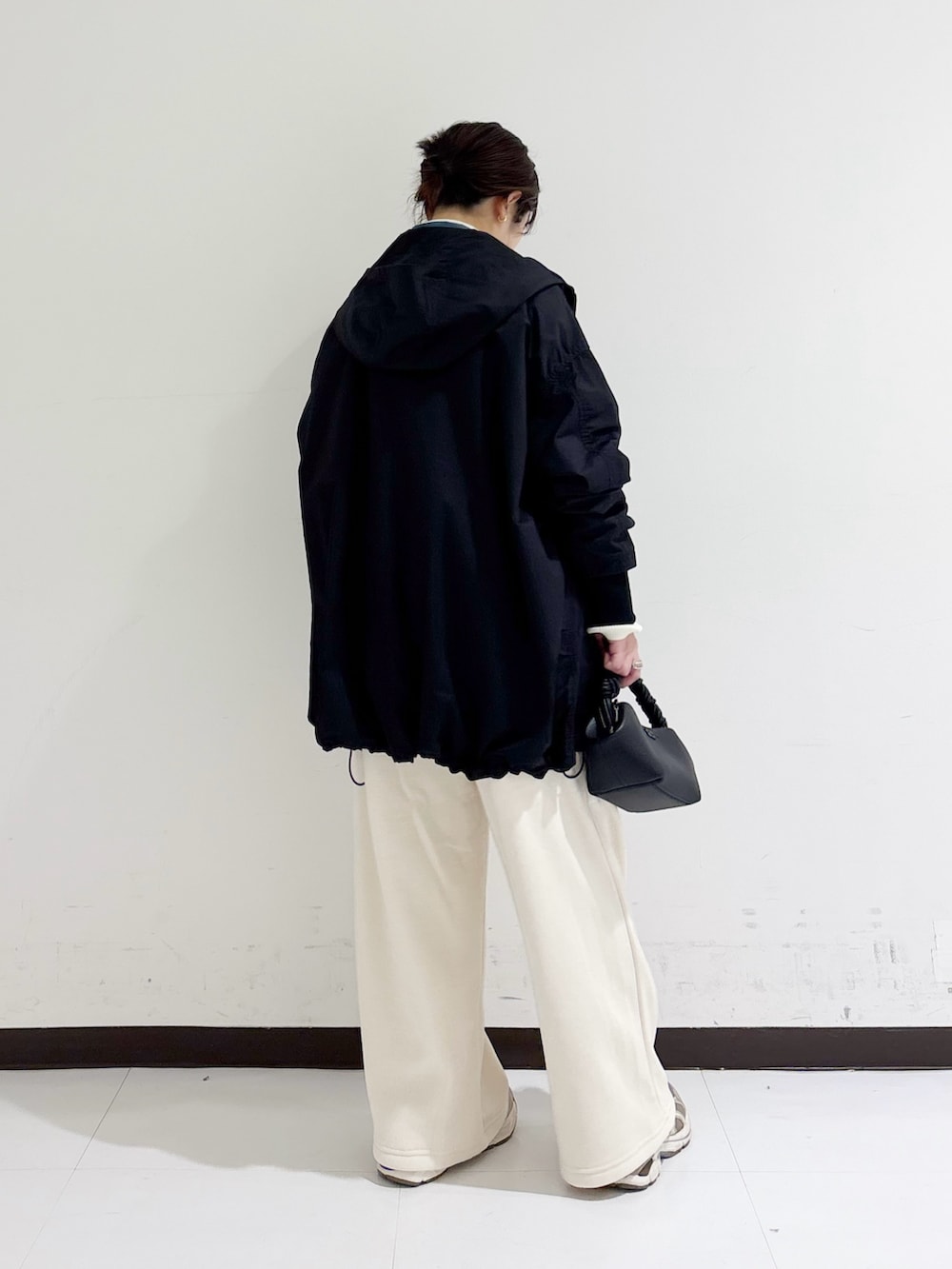 ホワイト系のニット/セーター、ブルー系のシャツ/ブラウス、ブラック系のマウンテンパーカーを着用したレディースの秋コーディネートの3枚目の写真