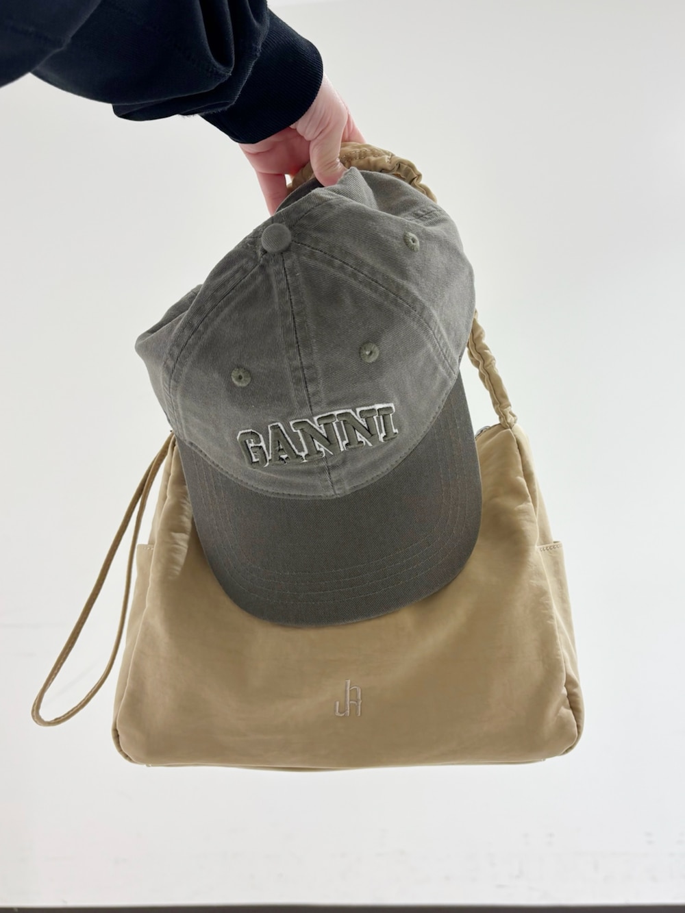 ブラック系のスウェット、ホワイト系のシャツ/ブラウス、ベージュ系のショルダーバッグを着用したレディースの冬コーディネートの8枚目の写真