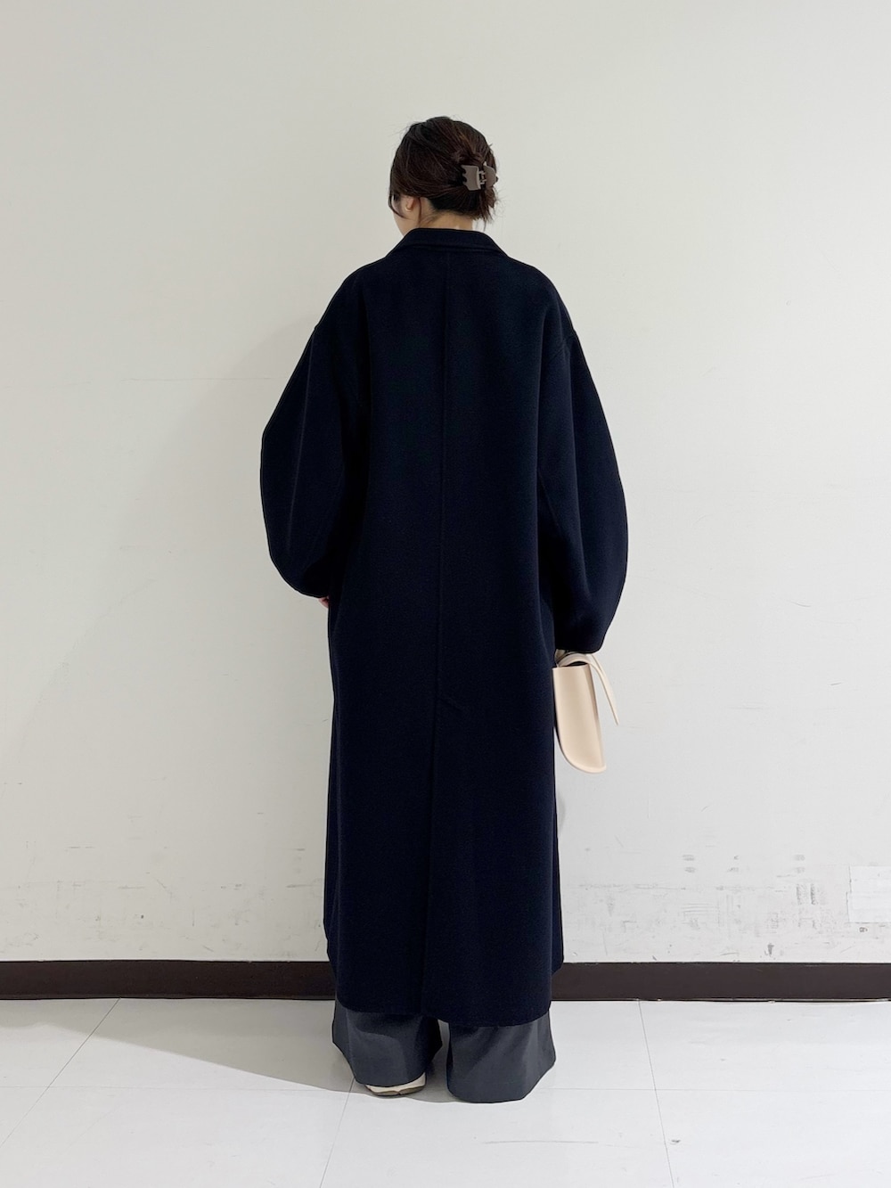 イエロー系のハンドバッグ、ピンク系のニット/セーター、ブルー系のテーラードジャケットを着用したレディースの冬コーディネートの3枚目の写真