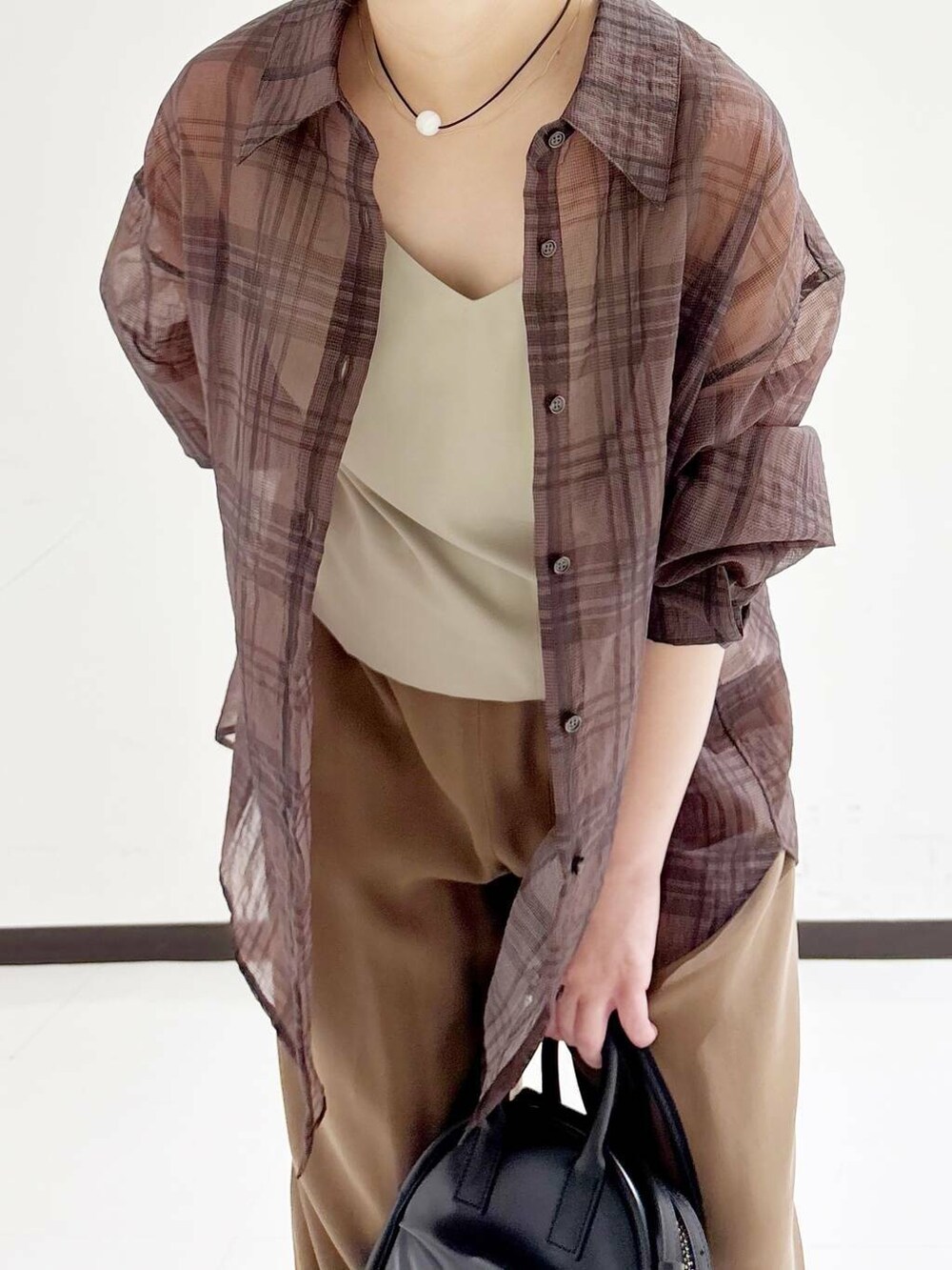 ブラック系のショルダーバッグ、ベージュ系のキャミソール、ブラック系のバレエシューズを着用したレディースの夏コーディネートの7枚目の写真