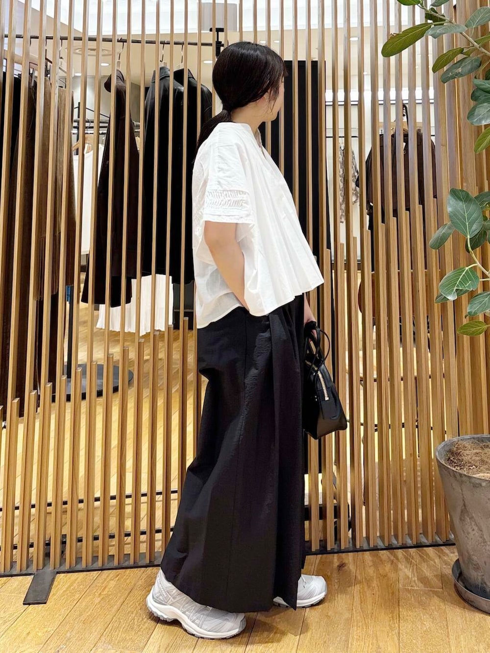 ブラック系のショルダーバッグ、ブラック系のその他パンツ、ホワイト系のシャツ/ブラウスを着用したレディースの夏コーディネートの3枚目の写真