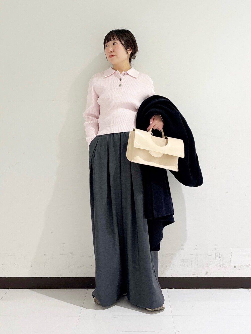 イエロー系のハンドバッグ、ピンク系のニット/セーター、ブルー系のテーラードジャケットを着用したレディースの冬コーディネートの8枚目の写真