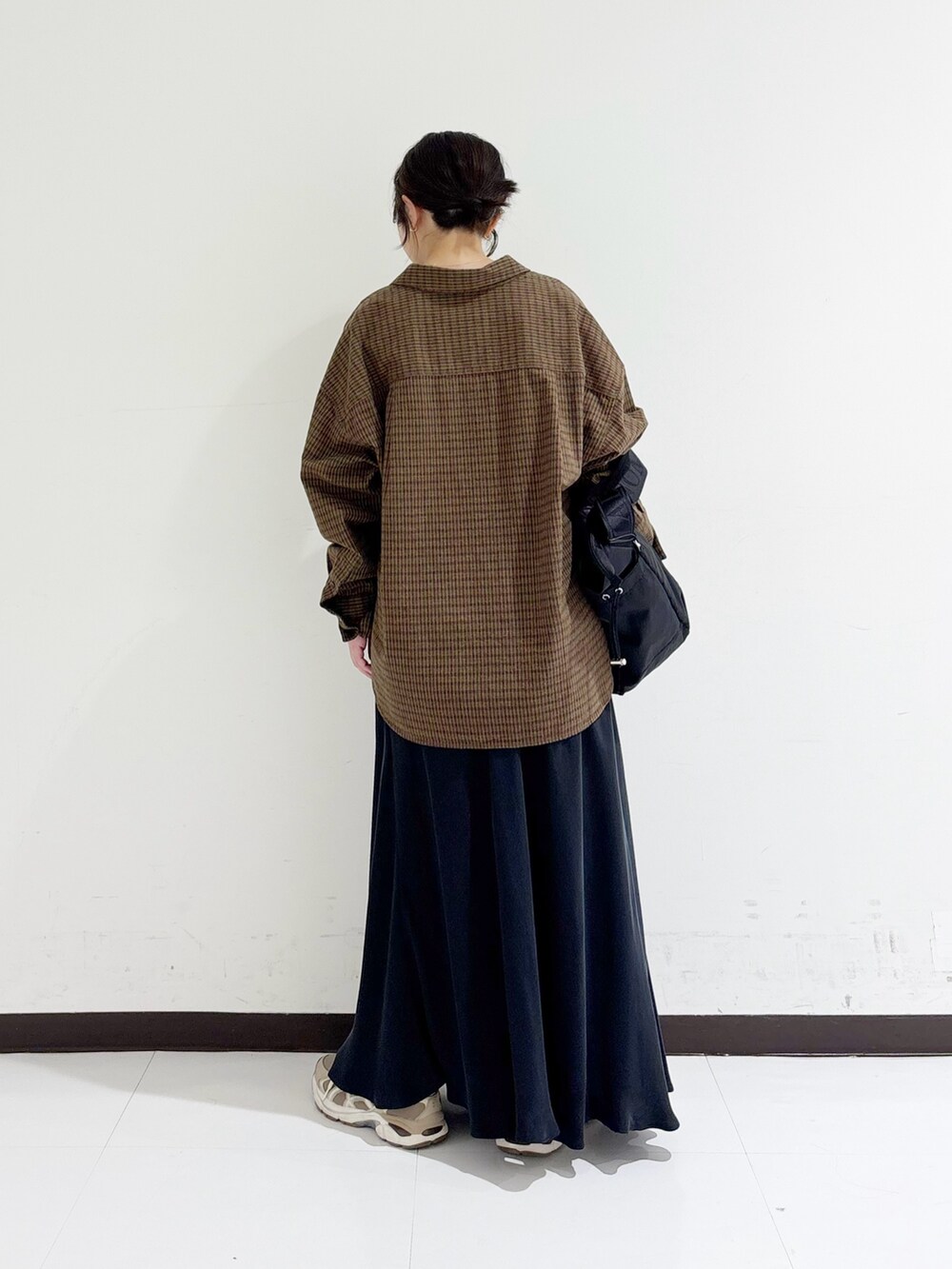 ブラウン系のシャツ/ブラウス、ブラック系のタンクトップ、ブラック系のショルダーバッグを着用したレディースの秋コーディネートの3枚目の写真