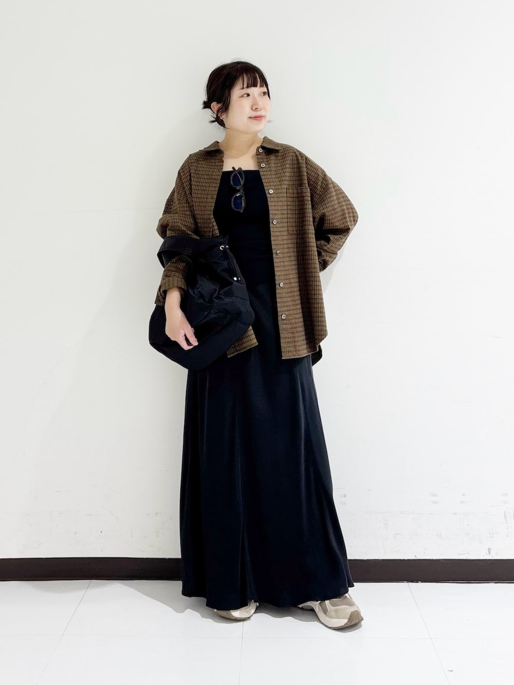 ブラウン系のシャツ/ブラウス、ブラック系のタンクトップ、ブラック系のショルダーバッグを着用したレディースの秋コーディネートの5枚目の写真