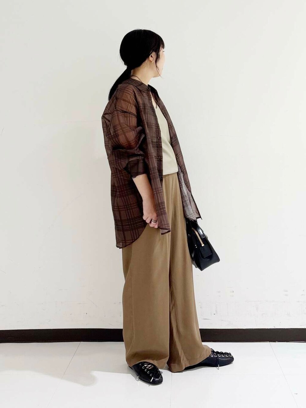 ブラック系のショルダーバッグ、ベージュ系のキャミソール、ブラック系のバレエシューズを着用したレディースの夏コーディネートの4枚目の写真