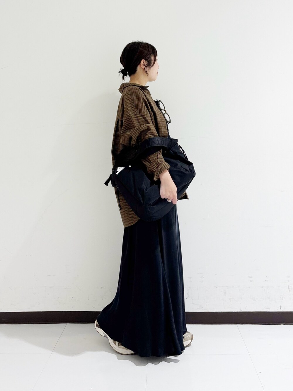 ブラウン系のシャツ/ブラウス、ブラック系のタンクトップ、ブラック系のショルダーバッグを着用したレディースの秋コーディネートの4枚目の写真