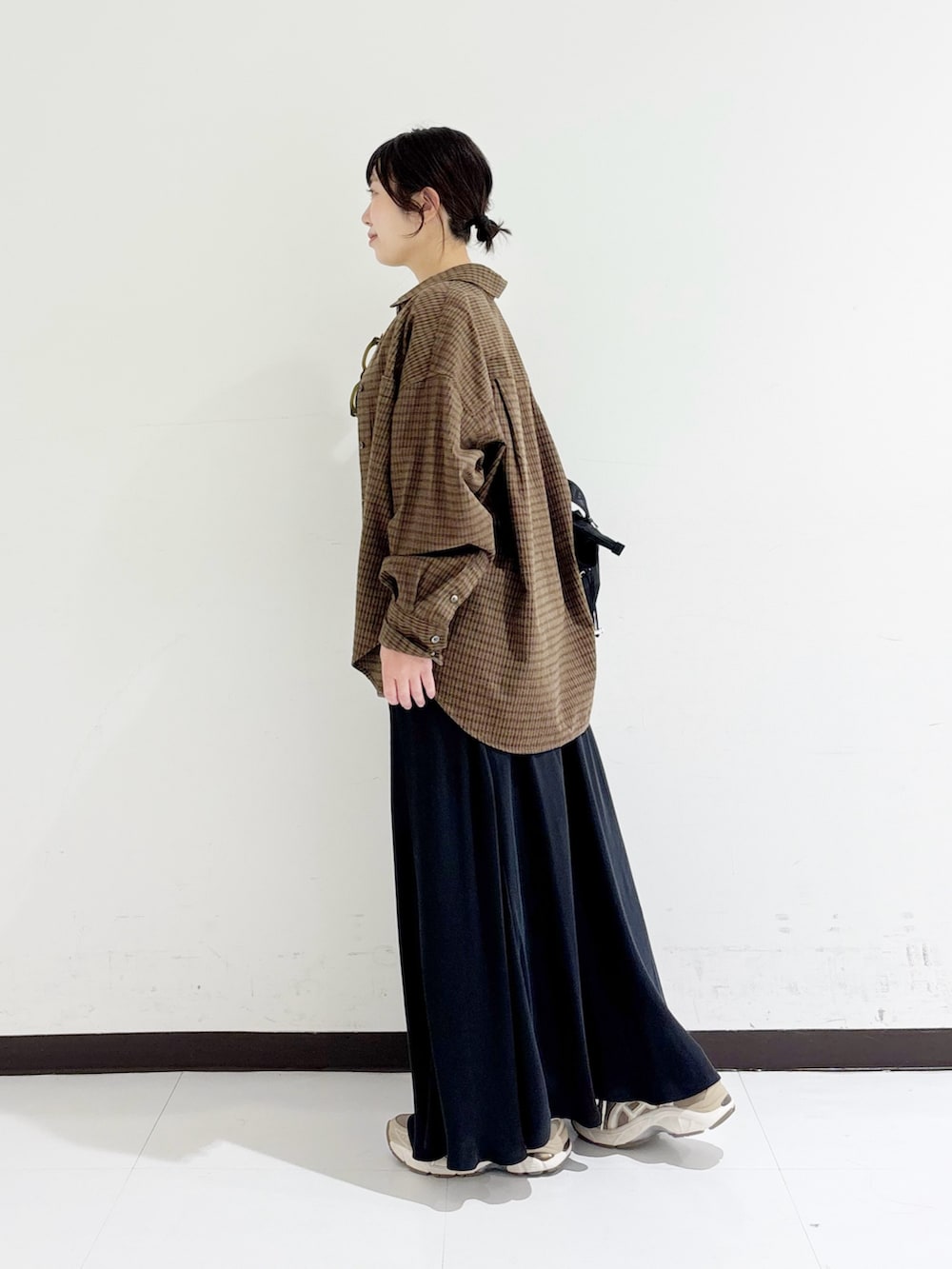 ブラウン系のシャツ/ブラウス、ブラック系のタンクトップ、ブラック系のショルダーバッグを着用したレディースの秋コーディネートの2枚目の写真