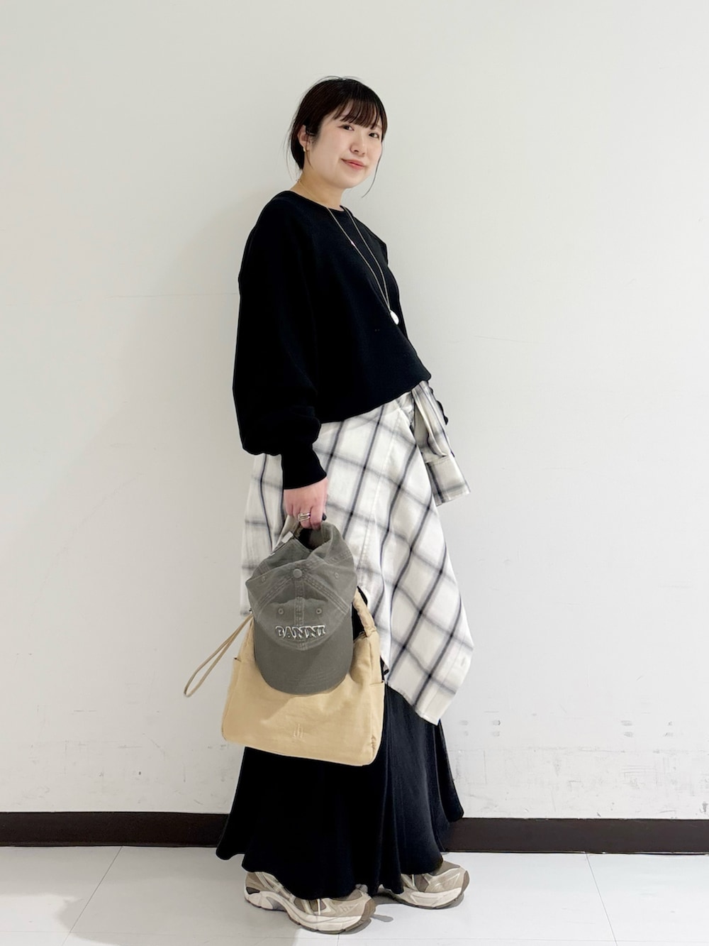 ブラック系のスウェット、ホワイト系のシャツ/ブラウス、ベージュ系のショルダーバッグを着用したレディースの冬コーディネートの4枚目の写真