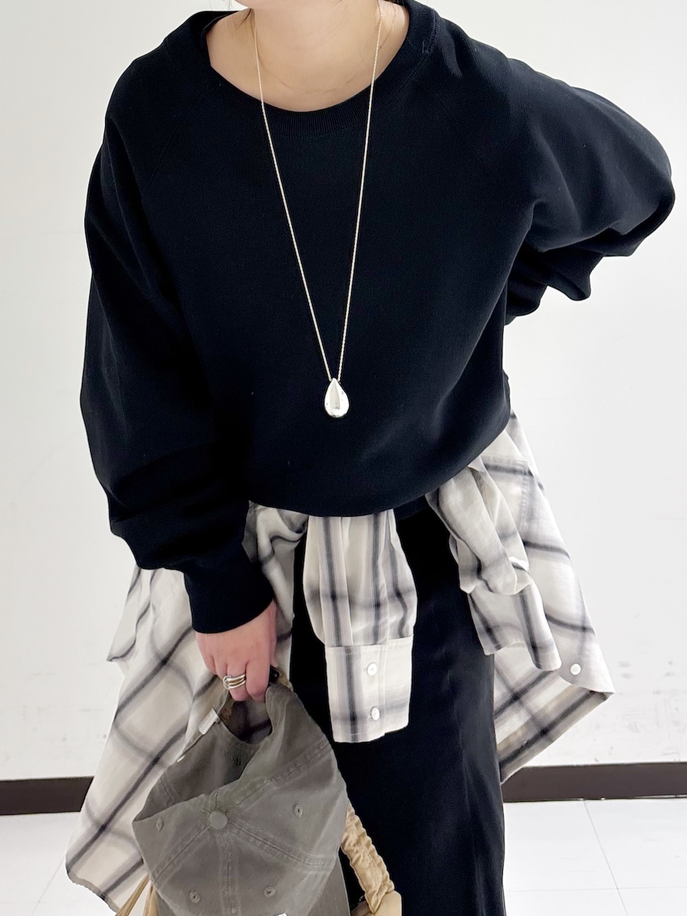 ブラック系のスウェット、ホワイト系のシャツ/ブラウス、ベージュ系のショルダーバッグを着用したレディースの冬コーディネートの7枚目の写真