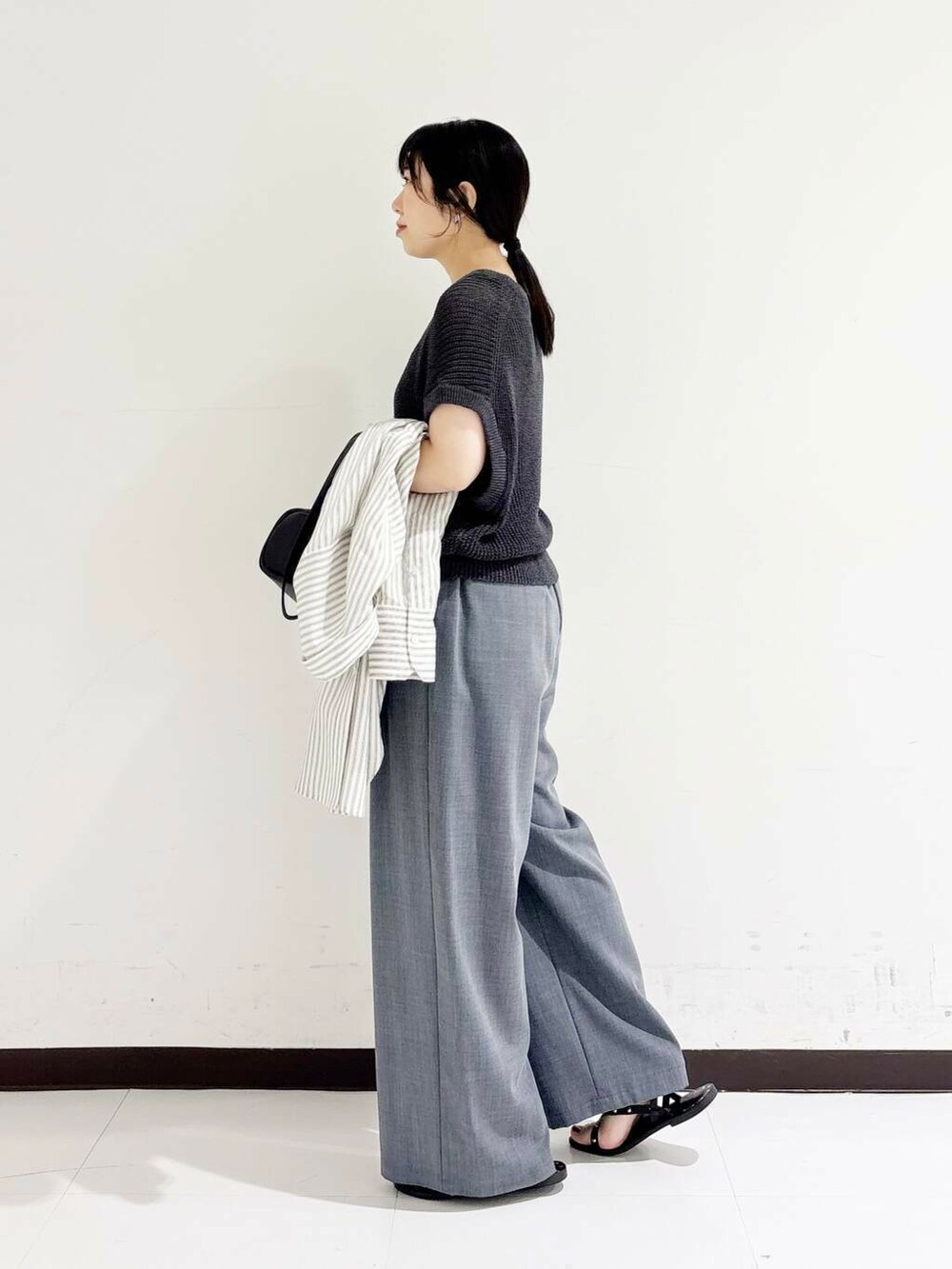 グレー系のその他パンツ、ブラック系のショルダーバッグ、ブラック系のサンダルを着用したレディースの夏コーディネートの3枚目の写真