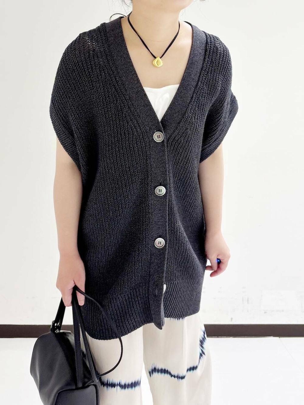 ホワイト系のタンクトップ、ホワイト系のその他パンツ、ブラック系のショルダーバッグを着用したレディースの夏コーディネートの7枚目の写真