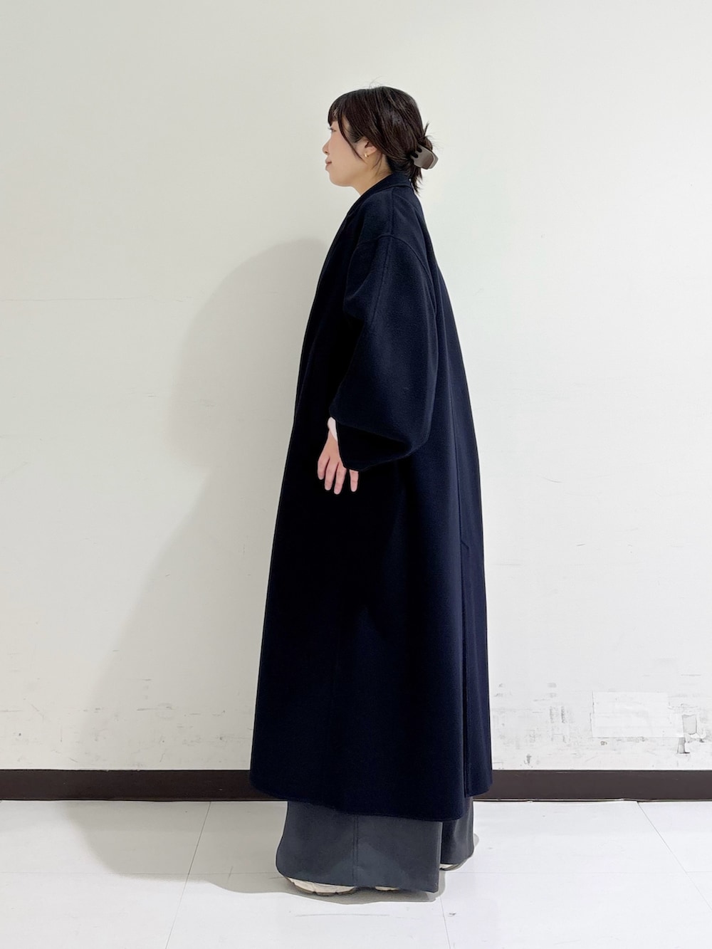 イエロー系のハンドバッグ、ピンク系のニット/セーター、ブルー系のテーラードジャケットを着用したレディースの冬コーディネートの2枚目の写真