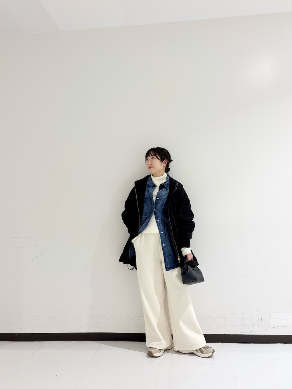 ホワイト系のニット/セーター、ブルー系のシャツ/ブラウス、ブラック系のマウンテンパーカーを着用したレディースの秋コーディネートの6枚目の写真