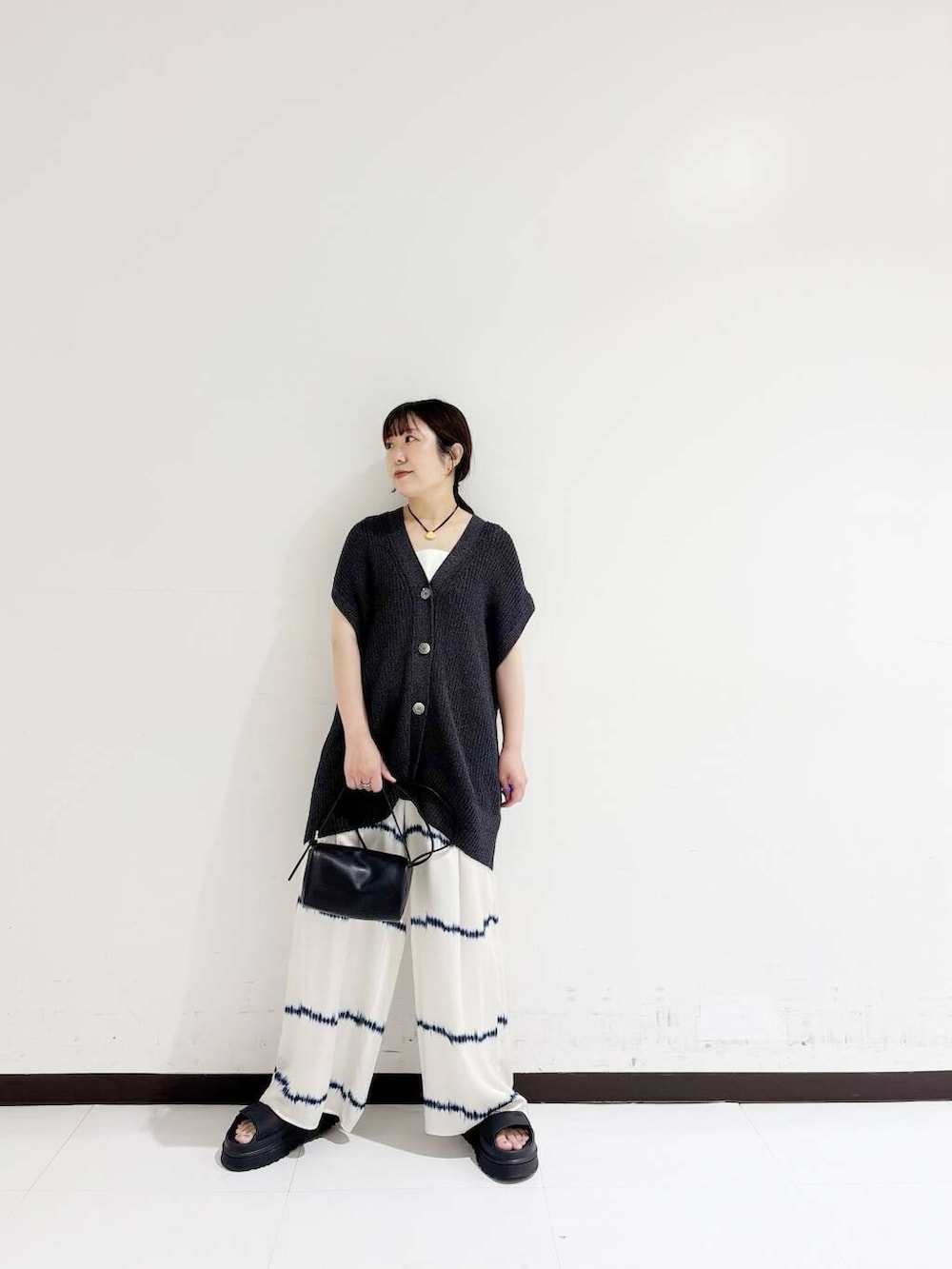 ホワイト系のタンクトップ、ホワイト系のその他パンツ、ブラック系のショルダーバッグを着用したレディースの夏コーディネートの6枚目の写真