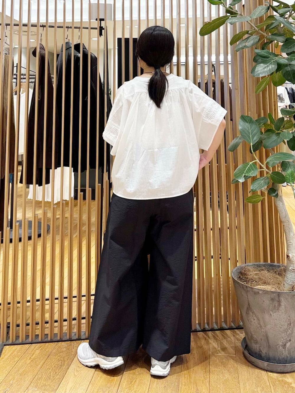 ブラック系のショルダーバッグ、ブラック系のその他パンツ、ホワイト系のシャツ/ブラウスを着用したレディースの夏コーディネートの2枚目の写真