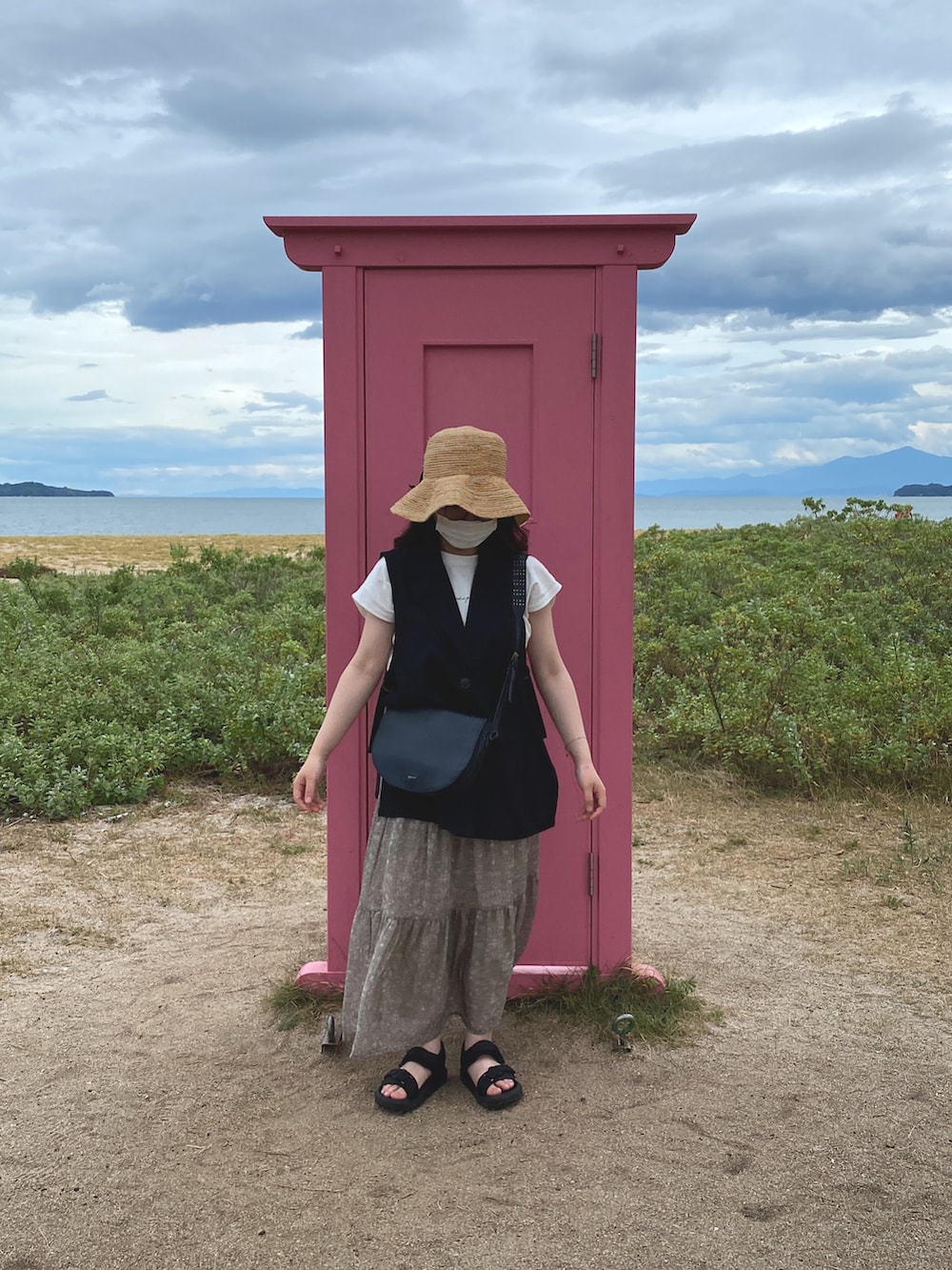 グレー系のスカート、ブラック系のサンダル、ブラック系のジャケット/アウターを着用したレディースの夏コーディネートの2枚目の写真