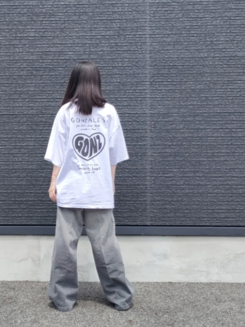 ブラック系のデニムパンツ、ホワイト系のTシャツ/カットソーを着用したレディースの夏コーディネートの5枚目の写真