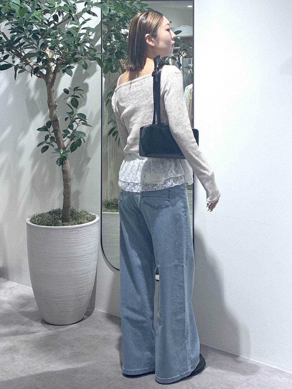 ブルー系のデニムパンツ、ブラウン系のTシャツ/カットソー、ブラック系のショルダーバッグを着用したレディースの春コーディネートの5枚目の写真