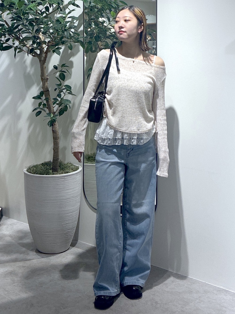 ブルー系のデニムパンツ、ブラウン系のTシャツ/カットソー、ブラック系のショルダーバッグを着用したレディースの春コーディネートの3枚目の写真