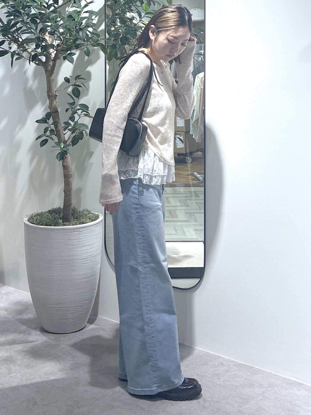 ブルー系のデニムパンツ、ブラウン系のTシャツ/カットソー、ブラック系のショルダーバッグを着用したレディースの春コーディネートの4枚目の写真