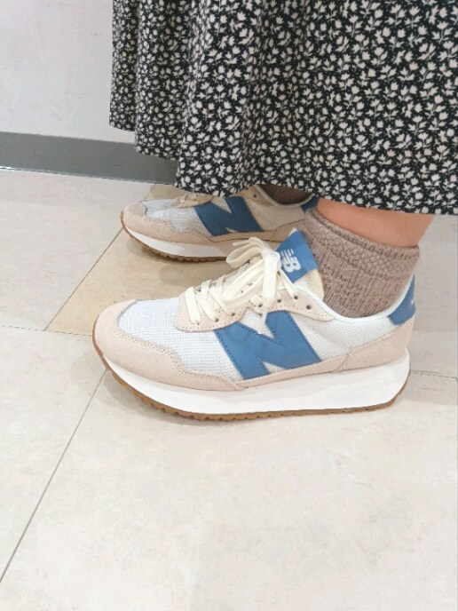 ホワイト系のスニーカーを着用したレディースの夏コーディネートの2枚目の写真