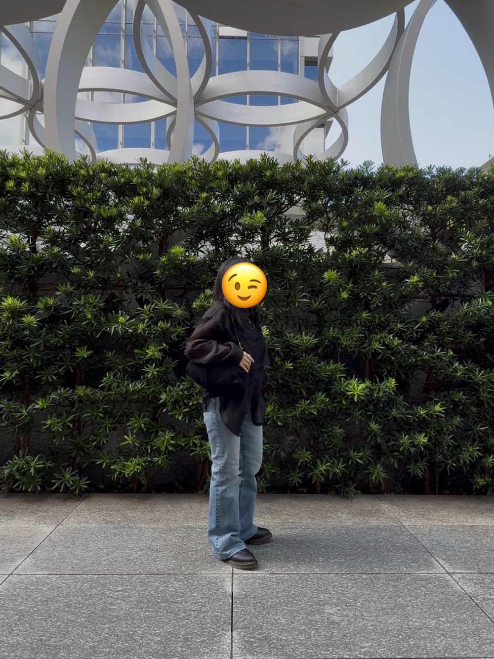 ブルー系のデニムパンツ、ブラック系のバレエシューズ、ブラック系のハンドバッグを着用したレディースの秋コーディネートの3枚目の写真