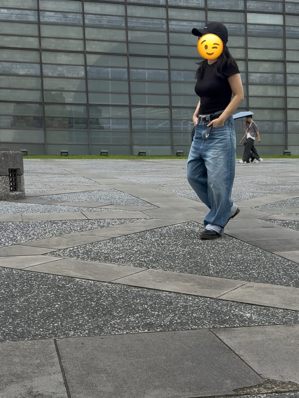 ブラック系のTシャツ/カットソー、ブラック系のドラムバッグ、ブルー系のデニムパンツを着用したレディースの秋コーディネートの3枚目の写真