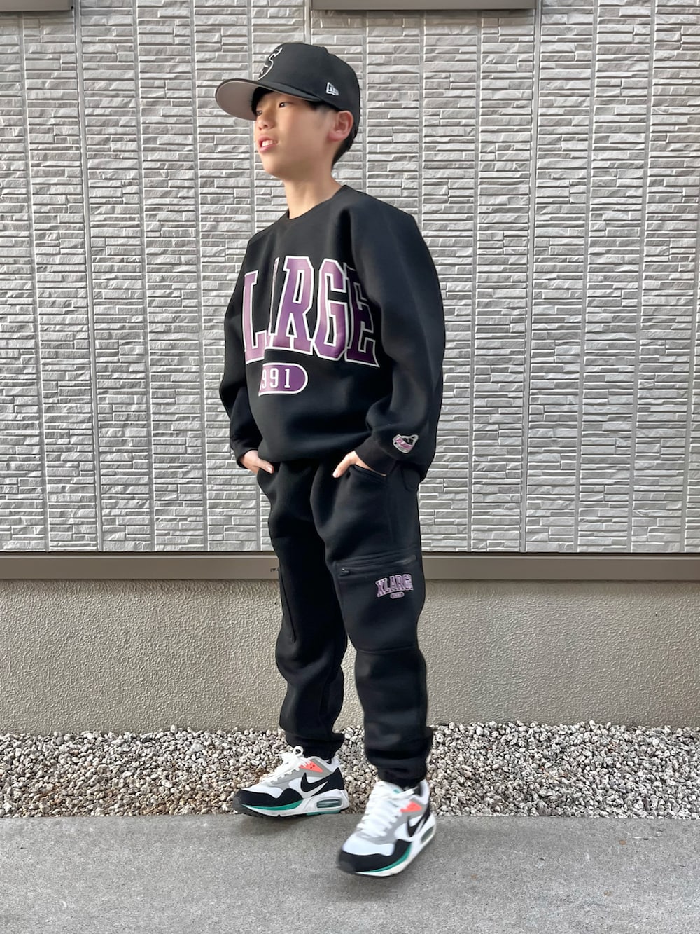 ブラック系のスウェット、ブラック系のスウェットパンツ、ホワイト系のスニーカーを着用したキッズの秋コーディネートの5枚目の写真