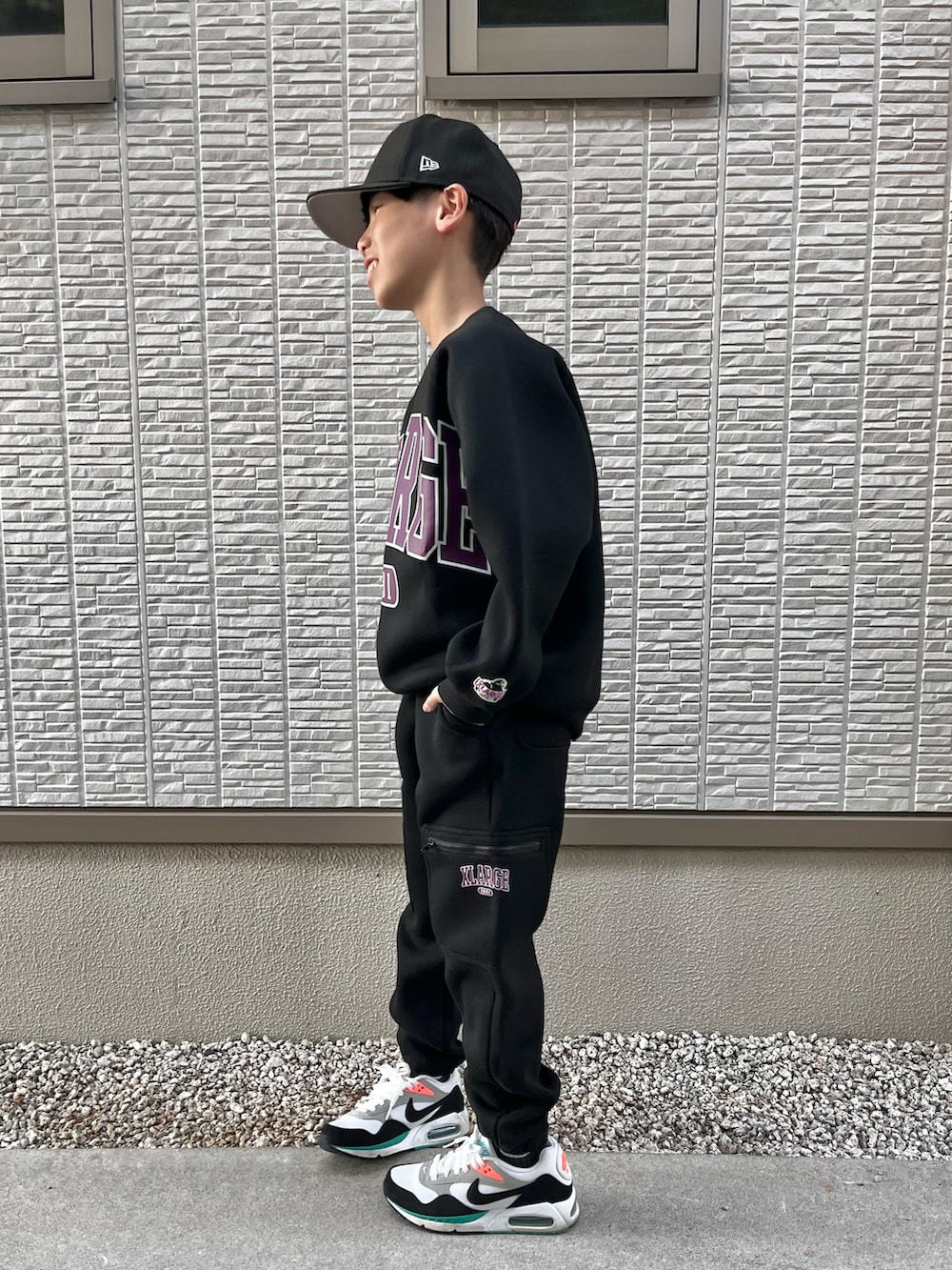 ブラック系のスウェット、ブラック系のスウェットパンツ、ホワイト系のスニーカーを着用したキッズの秋コーディネートの2枚目の写真