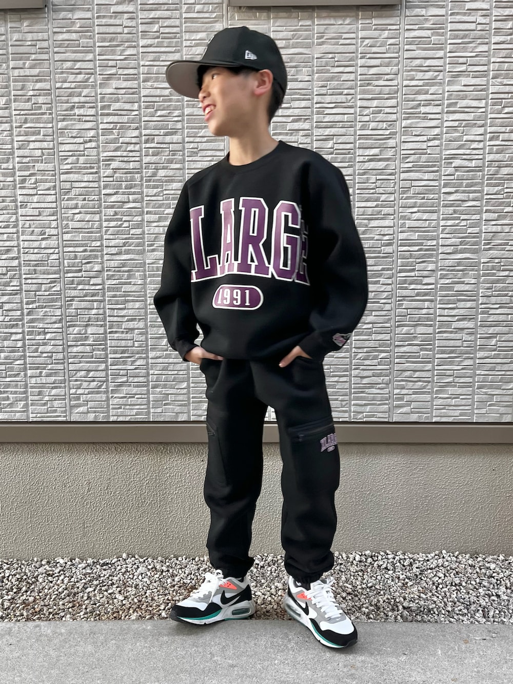 ブラック系のスウェット、ブラック系のスウェットパンツ、ホワイト系のスニーカーを着用したキッズの秋コーディネートの4枚目の写真