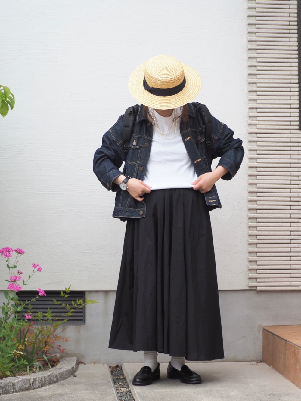 ブラック系のスカート、ホワイト系のTシャツ/カットソー、ブラック系のローファーを着用したレディースの夏コーディネートの2枚目の写真