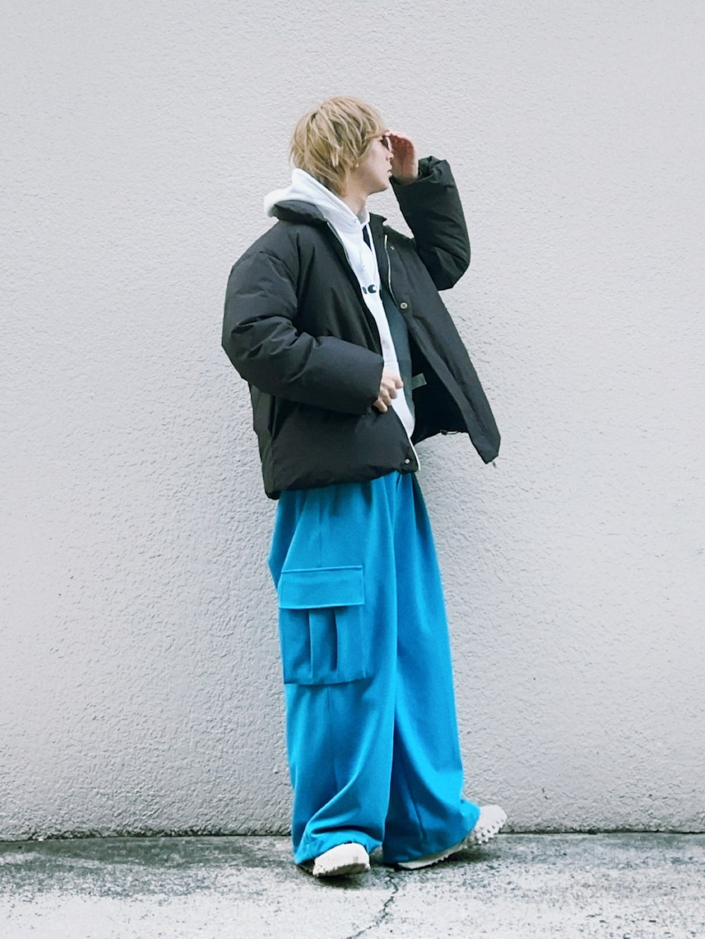 ブラック系のダウンジャケット/コート、ホワイト系のパーカー、ブルー系のカーゴパンツを着用したメンズの冬コーディネートの2枚目の写真