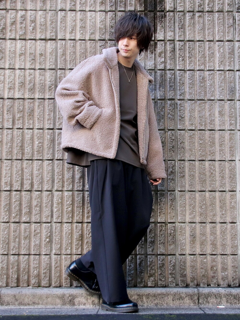 ブラウン系のTシャツ/カットソー、ベージュ系のブルゾン、グレー系のスラックスを着用したメンズの冬コーディネートの2枚目の写真