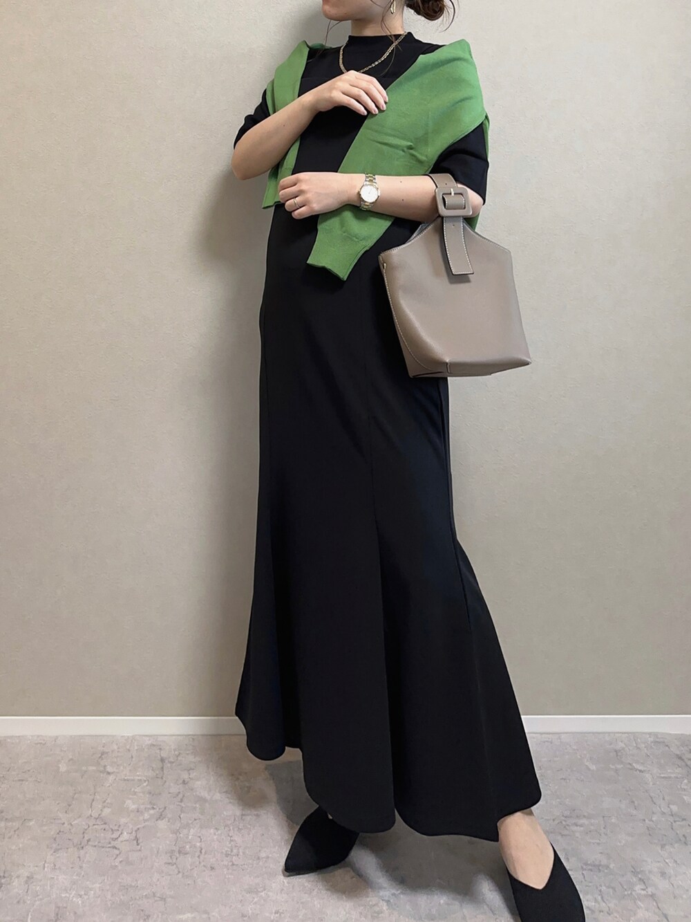 グリーン系のカーディガン/ボレロ、ブラック系のトップス、ブラック系のワンピースを着用したレディースの春コーディネートの3枚目の写真