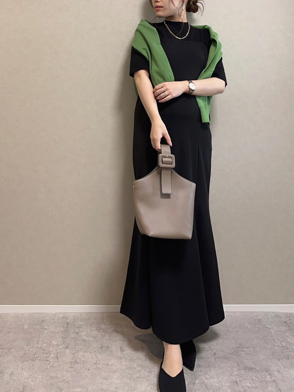 グリーン系のカーディガン/ボレロ、ブラック系のトップス、ブラック系のワンピースを着用したレディースの春コーディネートの4枚目の写真