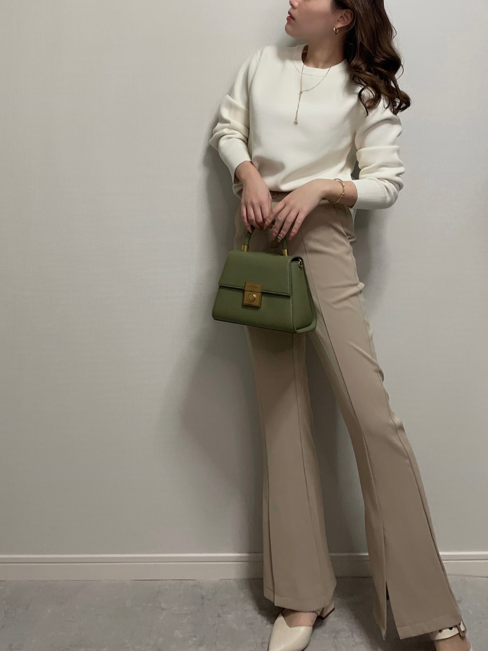 ホワイト系のニット/セーター、ベージュ系のパンツ、ホワイト系のシューズを着用したレディースの冬コーディネートの5枚目の写真