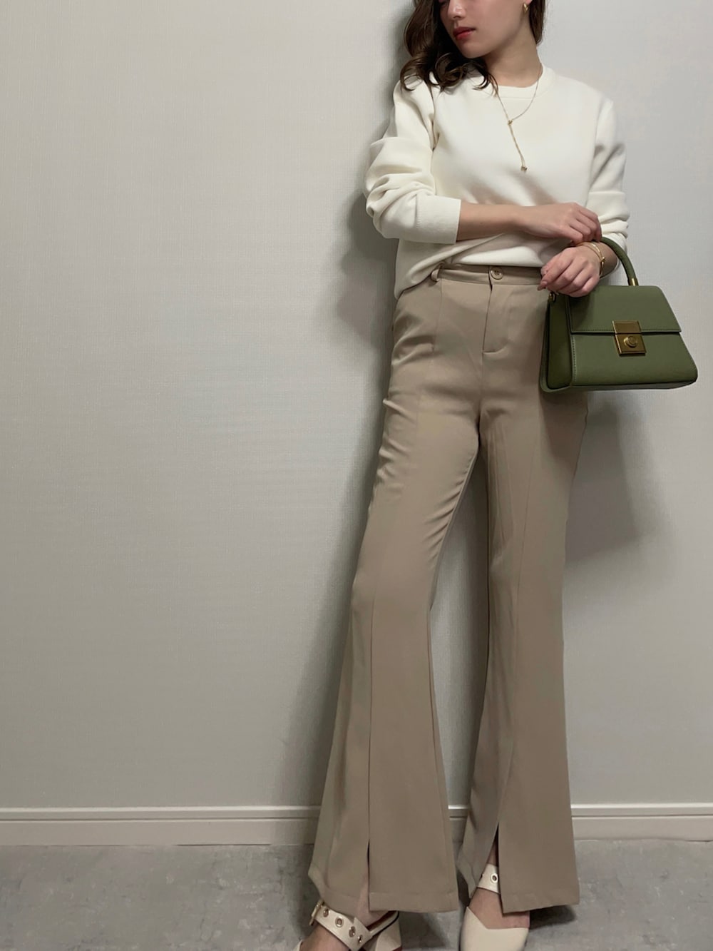 ホワイト系のニット/セーター、ベージュ系のパンツ、ホワイト系のシューズを着用したレディースの冬コーディネートの4枚目の写真