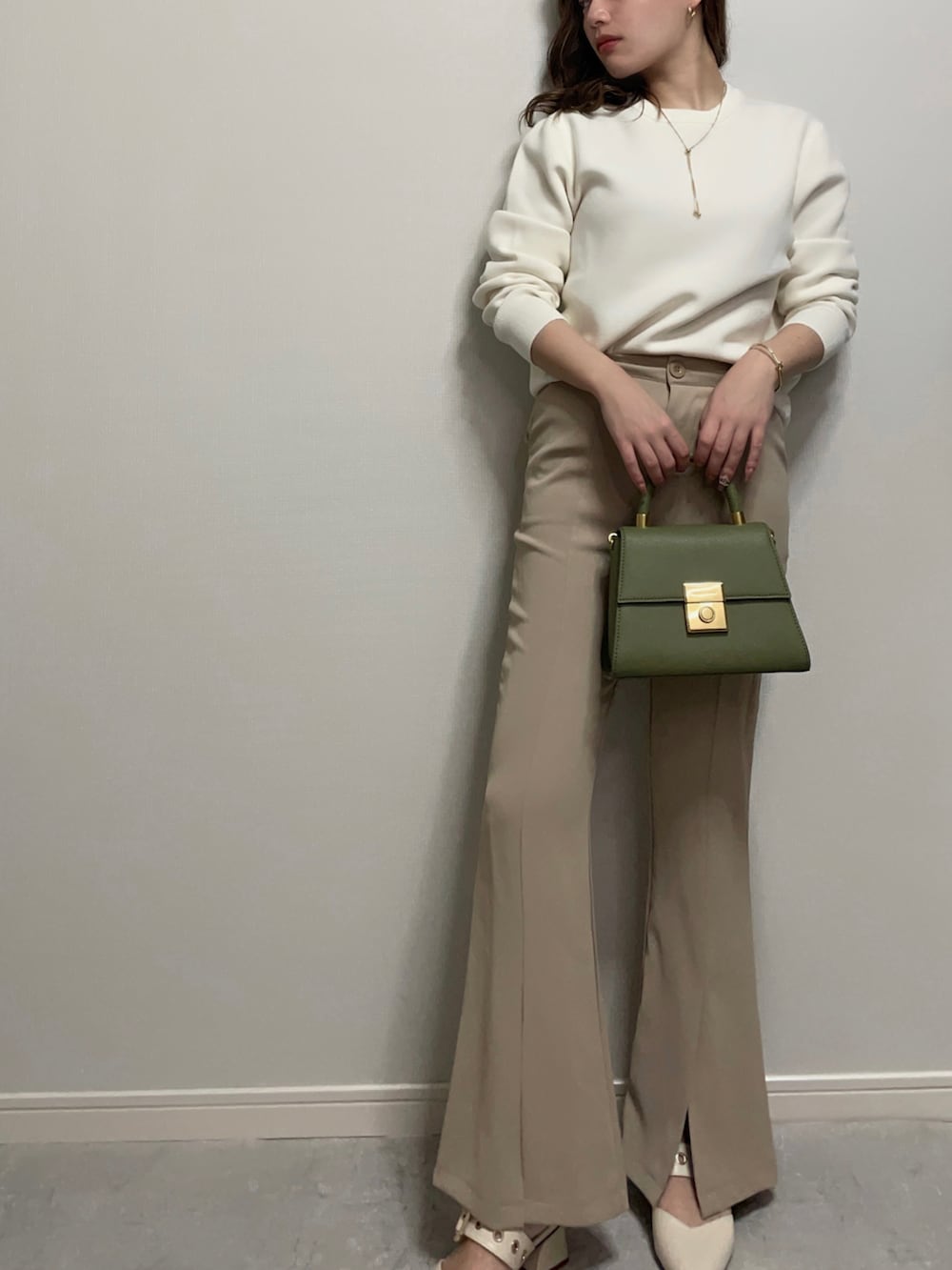 ホワイト系のニット/セーター、ベージュ系のパンツ、ホワイト系のシューズを着用したレディースの冬コーディネートの2枚目の写真